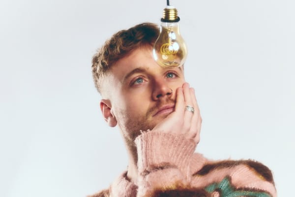 Portrait of Irish singer/songwriter Tadhg Daly staring at a lamp.